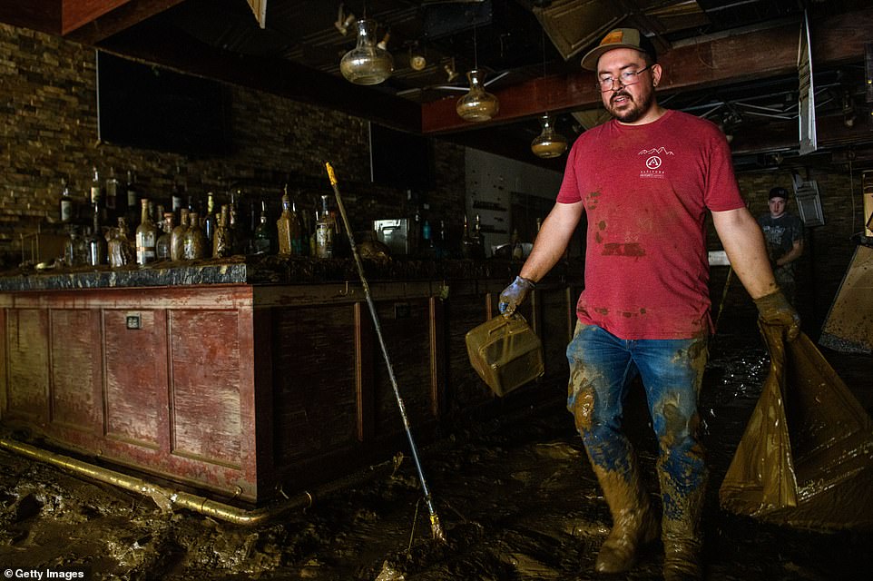 Corey Sizemore removes items from the Casablanca Cigar Bar in the Biltmore Village across from the Biltmore Estate in the aftermath of Hurricane Helene on October 1, 2024 in Asheville