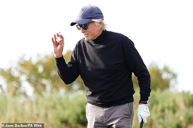 He added sunglasses to his look while working the famous Scottish golf course