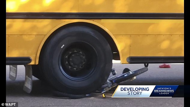 The school bus showing the youngster's bicycle sitting behind the front wheel