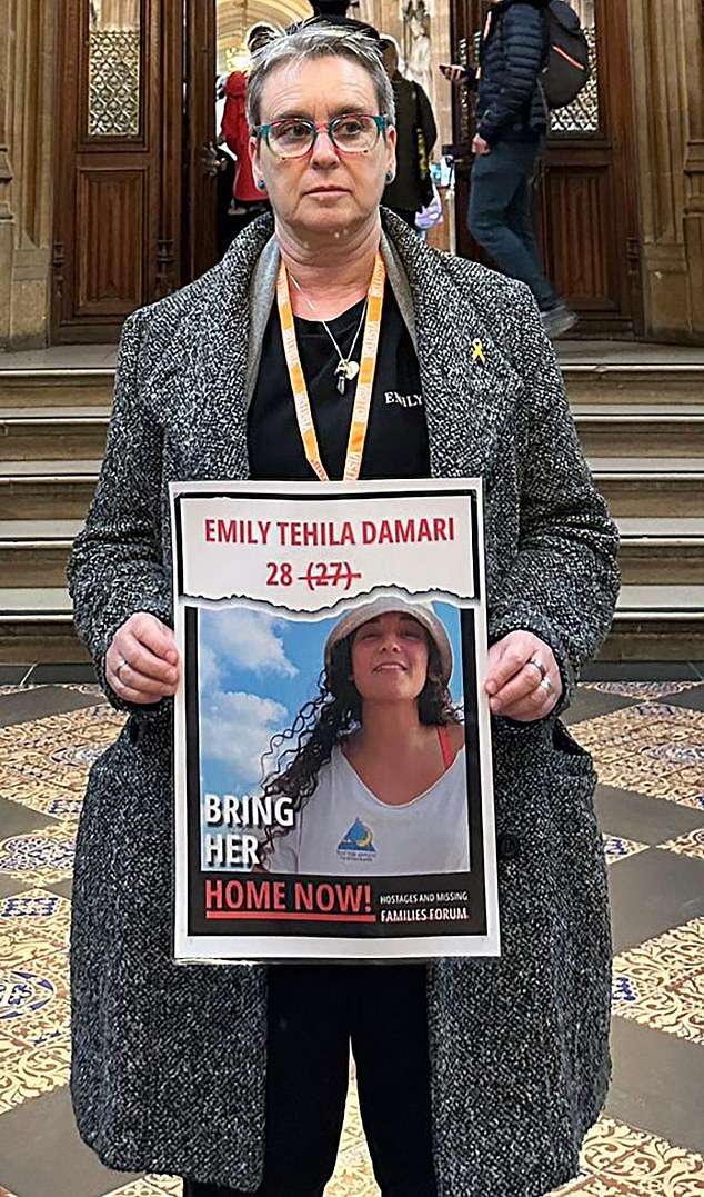 Mandy Damari is pictured holding a poster of her daughter Emily. She calls for her daughter's return