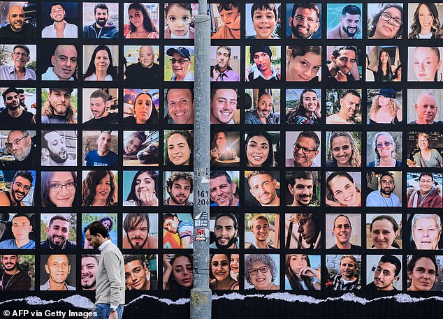 Monday marks the one-year anniversary of the largest massacre of Jews since the Holocaust: the October 7 attacks, in which 1,200 Jews were killed in cold blood by Hamas terrorists. Pictured: A man walks past a giant billboard with portraits of Israeli hostages held in Gaza since the October 7 attack