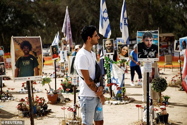 Shye Klein, 27, a photographer and Nova Festival survivor, looks at a portrait of Dor Avitan whom he met while attending the festival before the deadly Hamas attack on October 7, at the Nova Festival site in Reim , southern Israel