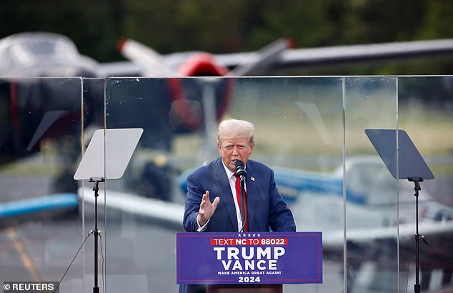 Republican presidential candidate and former U.S. President Donald Trump speaks from behind bulletproof glass during a campaign rally at the North Carolina Aviation Museum & Hall of Fame in Asheboro, North Carolina, U.S., August 21, 2024