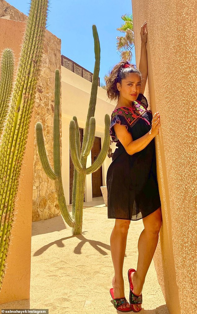 Two images showed the acclaimed actress standing next to a huge cactus plant as she leaned against the wall of an orange-brown building in a black mini dress, while the other two photos captured her laying back in the sun in a white lace dress.