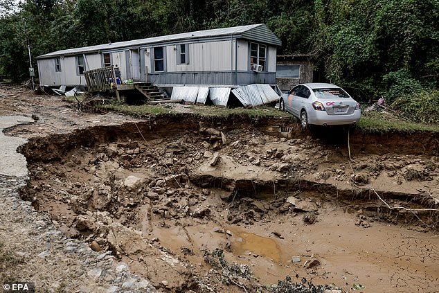 A mobile home and car along the Swannanoa River in the aftermath of catastrophic flooding caused by Tropical Storm Helene in Swannanoa, North Carolina, October 3