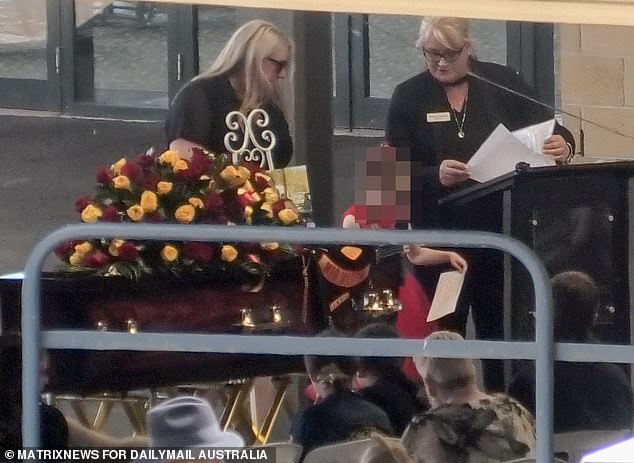 During the funeral procession, one of Mr Martin's young daughters paid tribute to her father just in front of his coffin, which was propped up and decorated with flowers.