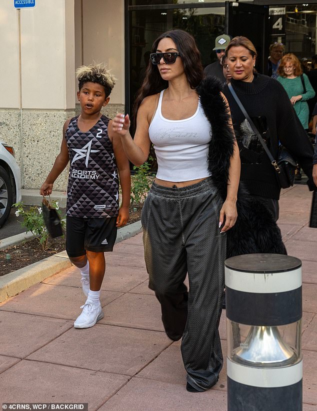 With several people close behind, Saint stayed close to his mother as he dressed in his black and gray Sports Academy jersey and matching black shorts.