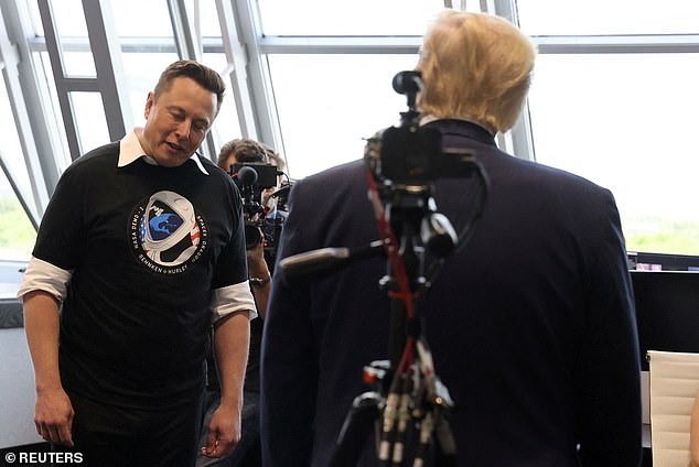 Elon Musk gives a slight bow of the head as US President Donald Trump congratulates him in the Firing Room Four after the launch of a SpaceX Falcon 9 rocket and Crew Dragon spacecraft on NASA's SpaceX Demo-2 mission to the International Space Station from NASA's Kennedy Space Center in Cape Canaveral, Florida, USA May 30, 2020