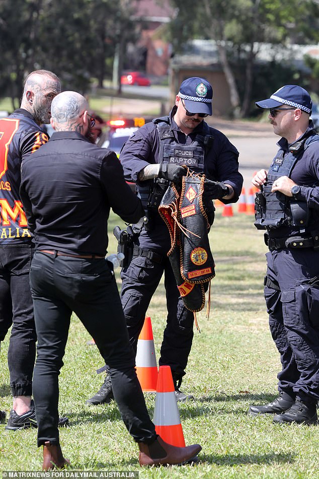 A police officer is seen checking the Bandidos colors