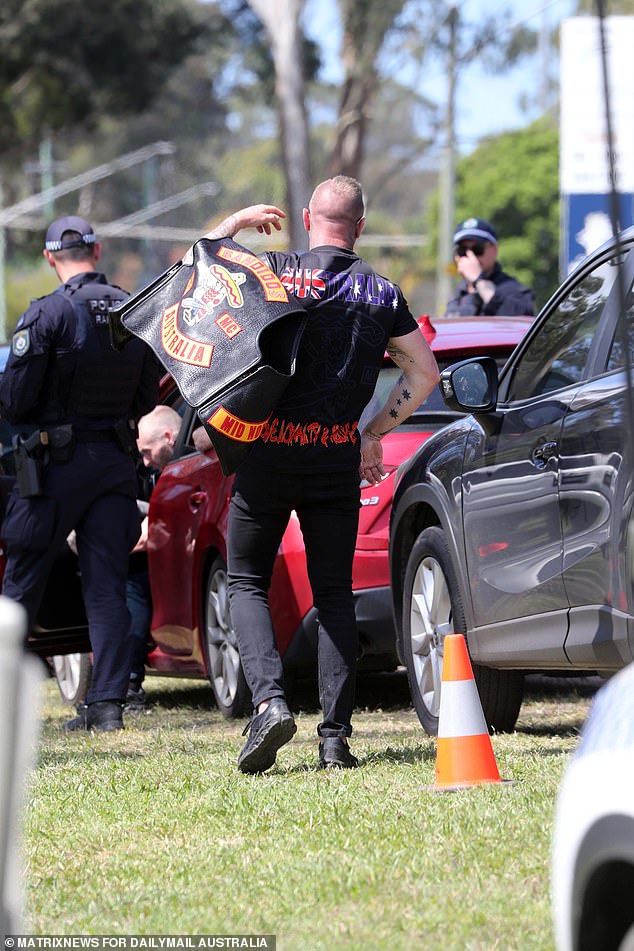 A man puts his colors back on after getting the green light from the police