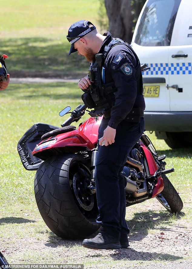 An officer is seen inspecting a motorcycle parked outside the Port Macquarie funeral