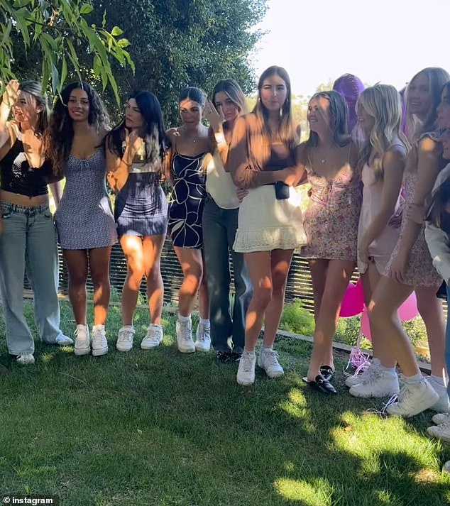 Fiona and her friends gathered for a memorable photo as they all stood under a shady tree in what appeared to be a spacious backyard