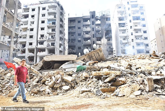 A man walks past the rubble of a building destroyed after Israeli attacks in Dahieh