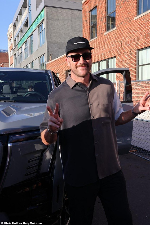 Kelce arrived at his charity event in style and posed with one of the cars on display