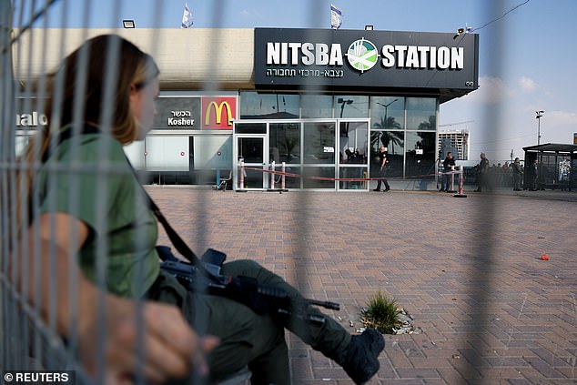 An Israeli Border Police officer sits near the scene of an attack in Beersheba, southern Israel, October 6