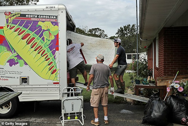 A North Carolina resident rescues what remains of his belongings from his flooded home in Kinston after Hurricane Florence struck in 2018.