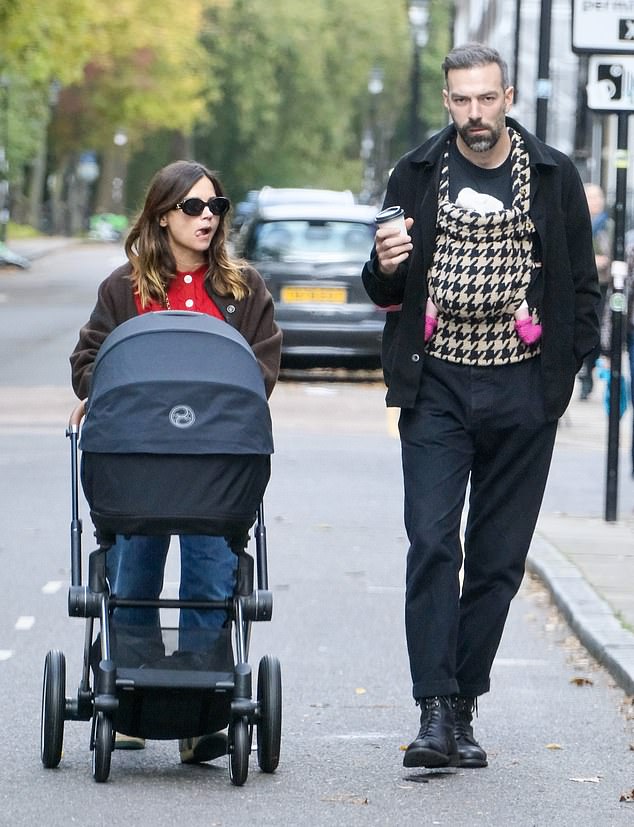 Meanwhile, Jamie, 35, cradled the couple's little one against his chest in a baby carrier, with the newborn's feet sticking out, dressed in bright pink socks.