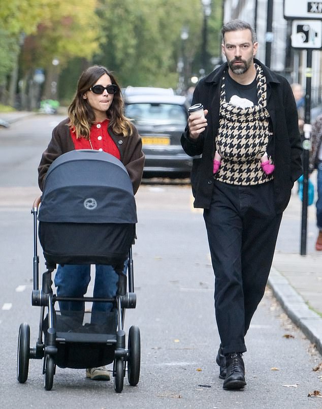 The director sipped a cup of coffee while chatting with Jenna, wearing an all-black ensemble of a jacket, jeans and a plain T-shirt