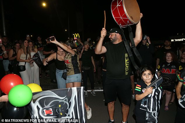 Flags, balloons, replica jerseys, Penrith Panthers t-shirts and a man with a drum