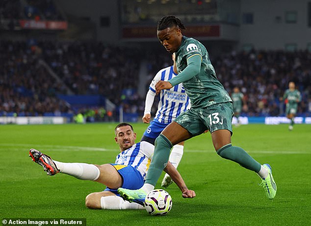 Lewis Dunk pictured (left) performing a slide tackle against Spurs left-back Destiny Udogie