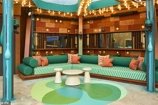 A canopy includes a green and pink striped sofa with ceiling lighting