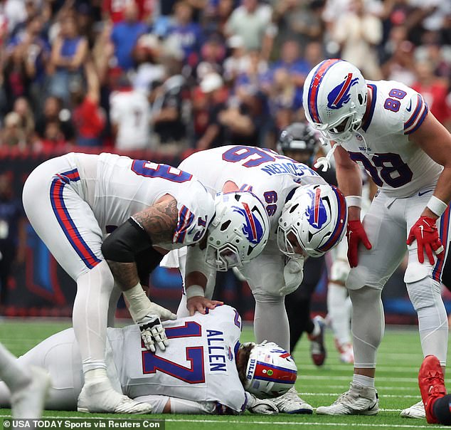 Concerned teammates stood over the quarterback after his head bounced off the ground