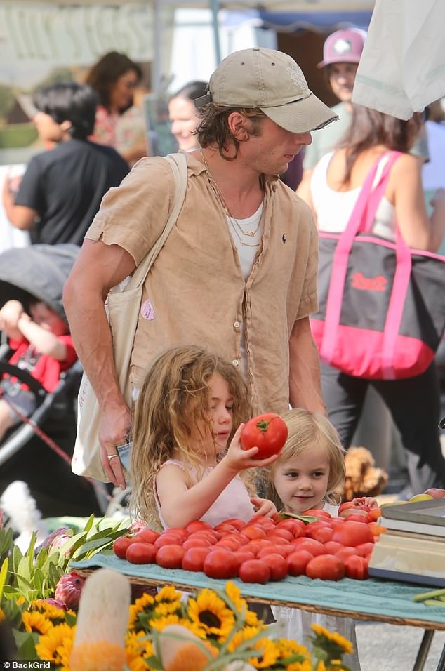 The hands-on dad could be seen looking over the fruit and vegetables with his daughters Ezer, five, and Dolores, three