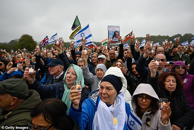 Crowds hold up candles and banners during a minute's silence showing photos of Israeli hostages as British Jewish groups commemorate the first anniversary of October 7.