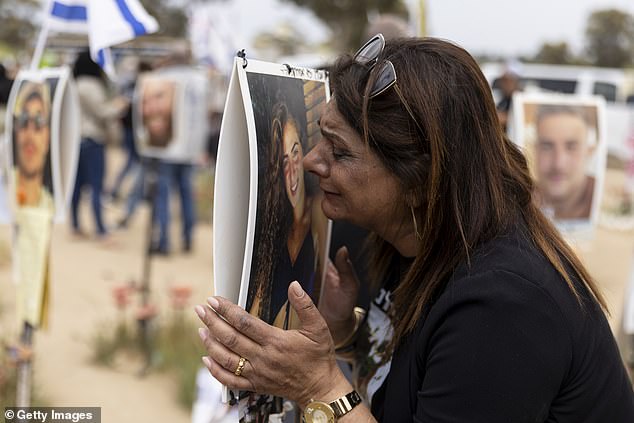 Orly Efraim reacts at the marker of her niece Eden Liza Auhaion, who was killed during the deadly October 7 Hamas attack on the Nova music festival on April 7, 2024 in Re'im, Israel