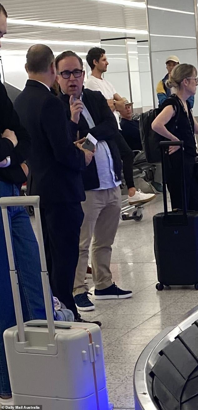 The ex-Qantas chief was seen talking to another man early on Monday morning as he waited for his luggage at the Sydney airport carousel after arriving from an overseas trip.