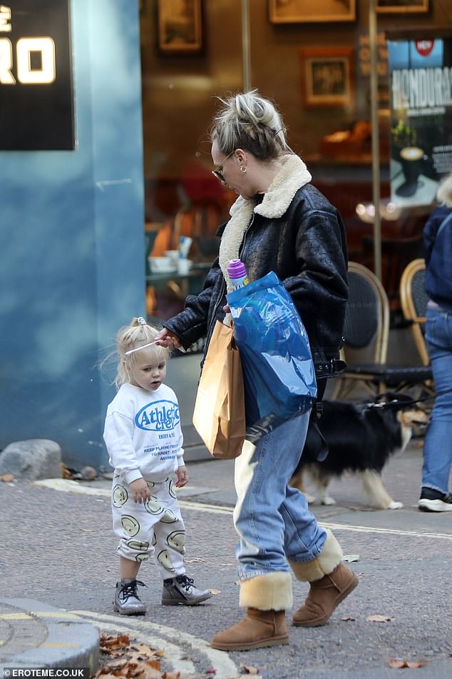 She paired it with a black T-shirt, loose fitting jeans in a light wash and a pair of tan Ugg boots