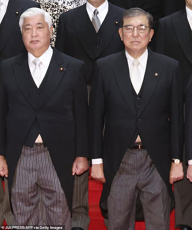 In the original, unedited images, which appeared in local media publications, small pieces of white shirts can be seen peeking out from under the suits of the prime minister (right) and Japan's defense minister (left).