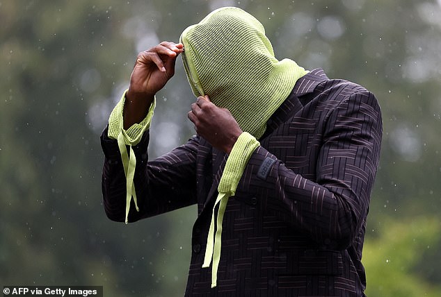 The Liverpool star arrived with a bizarre yellow hood covering his face