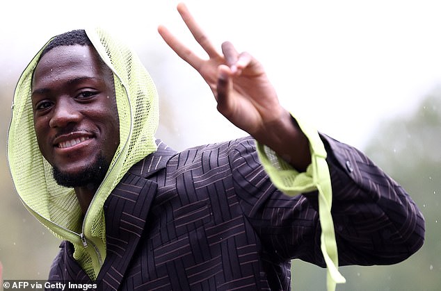 Konate smiled and posed for the cameras as he unzipped his mask to reveal himself