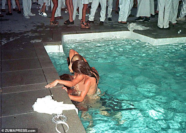 Two women pour champagne down the throat of a third woman at Combs' Labor Day party at his East Hampton home in 1998