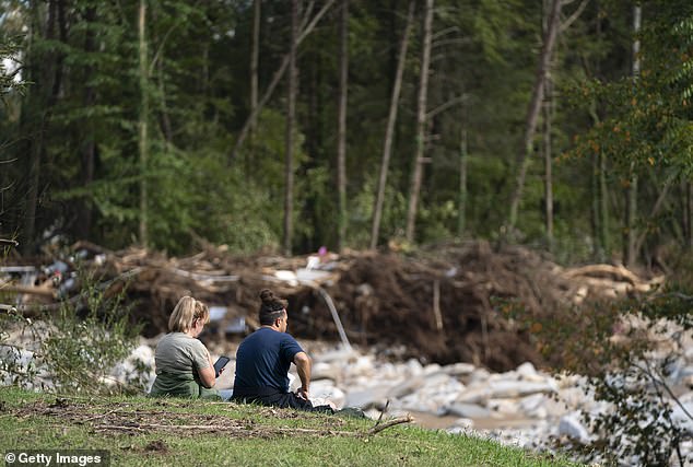 People watch for flood damage in the aftermath of Hurricane Helene on October 3, 2024 in Bat Cave, North Carolina. More than 220 people died as a result of the storm