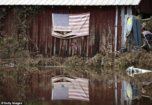 An American flag is reflected in the water left after Hurricane Helene on October 4