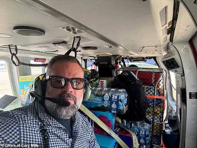 Mills aboard a helicopter full of diapers, water, food and other necessities