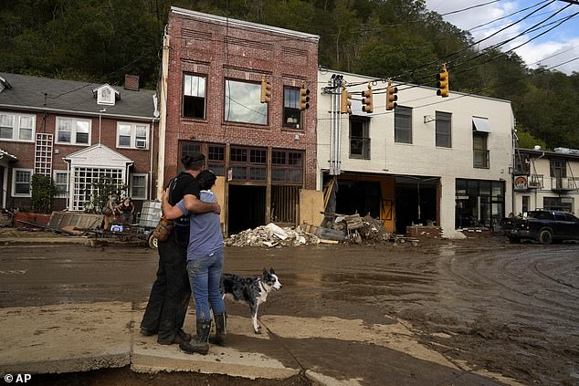 Resident Anne Schneider, right, hugs her boyfriend Eddy Sampson as they survey the damage left behind by Hurricane Helene on Tuesday, October 1, 2024 in Marshall, North Carolina