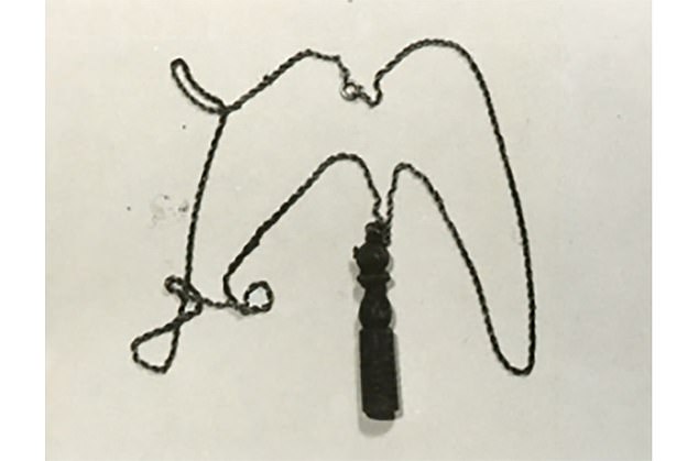 The unidentified girl had a gold-colored metal chain with a brown wooden bowling pin-shaped pendant, which was often worn by conscripts who had completed their military service.