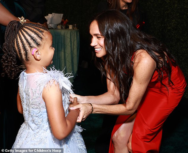 Bending down to meet young Ella Nelson at the Children's Hospital Gala in Los Angeles on Saturday showed why it's unwise to wear a slit dress on such occasions