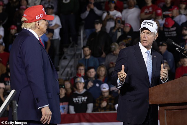 Republican presidential candidate, former President Donald Trump, listens as Senator Ron Johnson speaks during a rally at Dodge County Airport on October 6, 2024