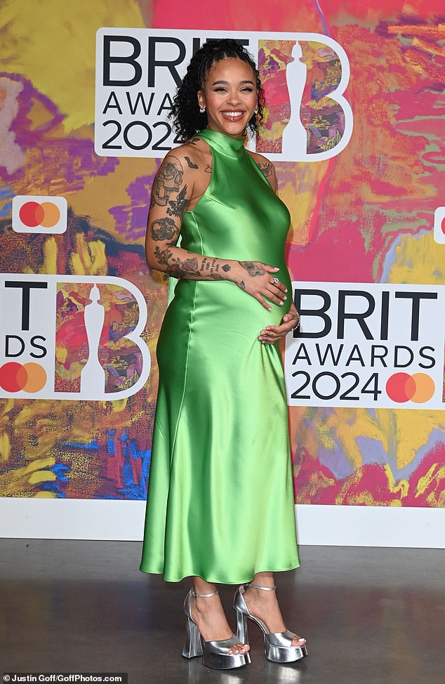 The host looked sensational in a green satin dress that hugged her blossoming bump, which she cradled as she interviewed stars ahead of the ceremony