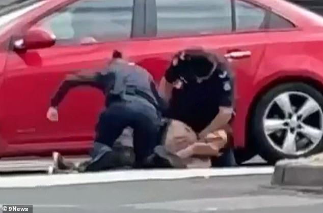 The footage shows a female officer punching the shirtless man several times (photo)