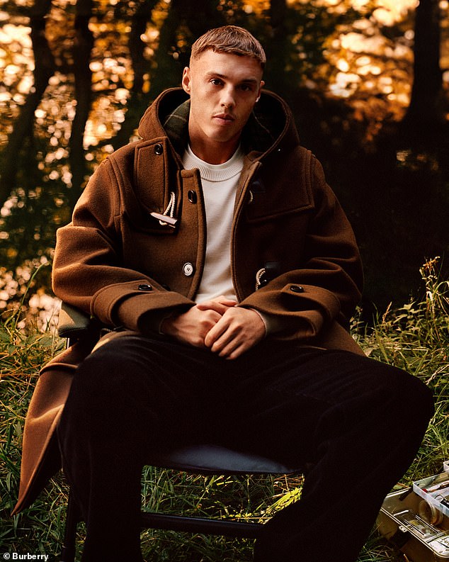 Footballer Cole Palmer posed in a dark brown trench coat worn over a white T-shirt and black trousers