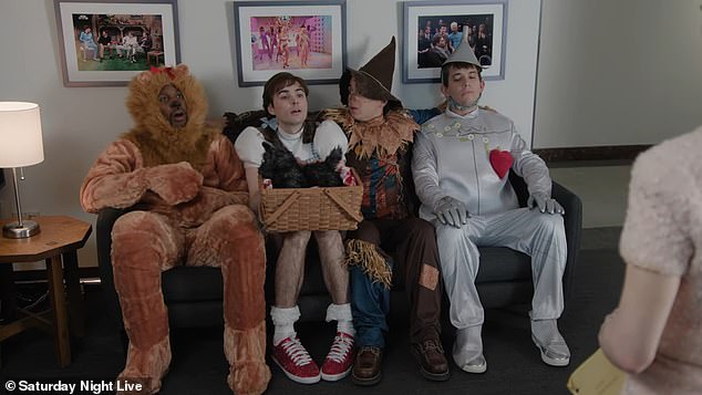 The camera then cut to (from L-R) SNL's Devon Walker, Michael Longfellow, Marcello Hernández and Andrew Dismukes, dressed in cheesy costumes of the Lion, Dorothy Gale, Scarecrow and Tin Man: 