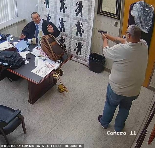 The video shows Stines pointing his gun at Mullins as his hands are huddled behind his desk