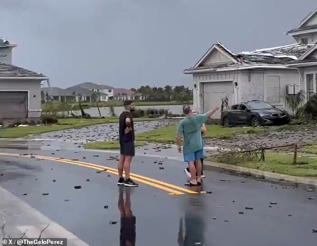 Residents discuss the damage in the middle of the street