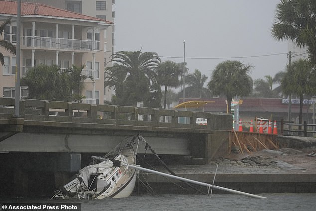 A boat damaged by Hurricane Helene rests against a bridge before the arrival of Hurricane Milton, in South Pasadena, Florida, Wednesday, Oct. 9, 2024. (AP Photo/Rebecca Blackwell)