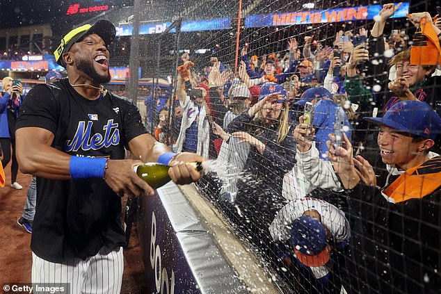 Starling Marte sprays champagne into the stands after the Mets beat the Phillies